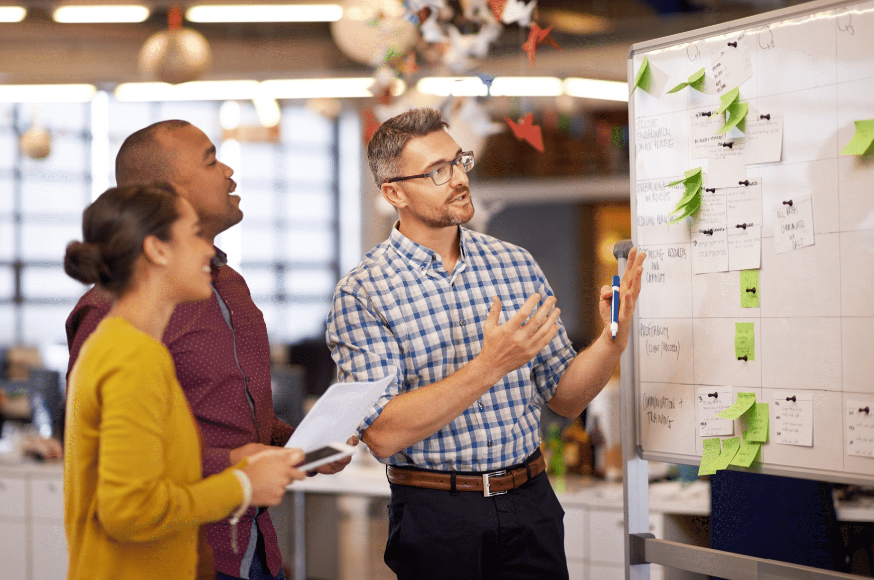 A man explaining SEO content strategy to his team of two in front of a whiteboard